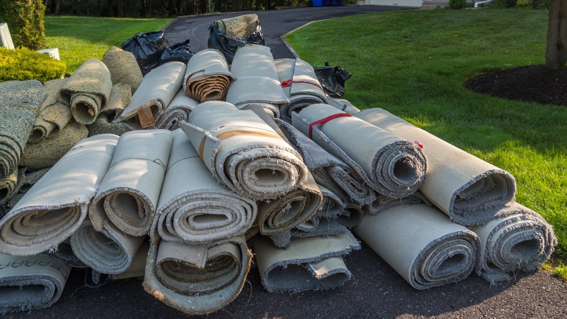 rolls of old carpet on driveway
