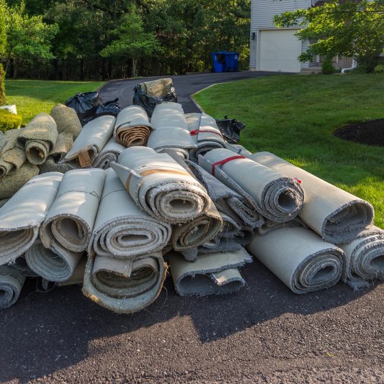 rolls of old carpet on driveway